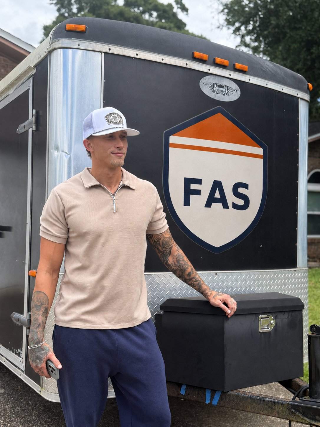 Connor Brown, owner of Fortified Asset Solutions, standing beside his FAS work trailer