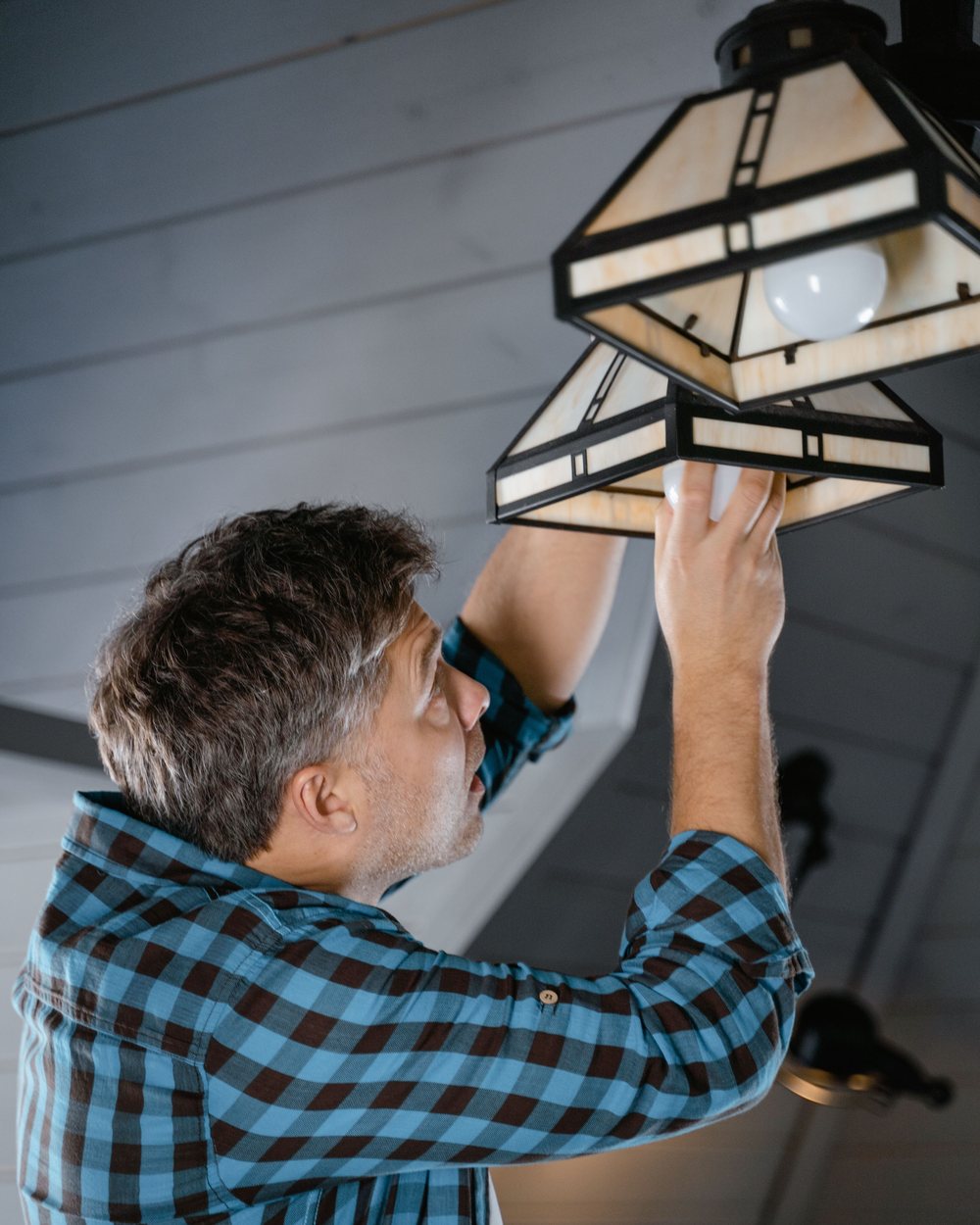 Installing a ceiling light fixture, illustrative stock photo