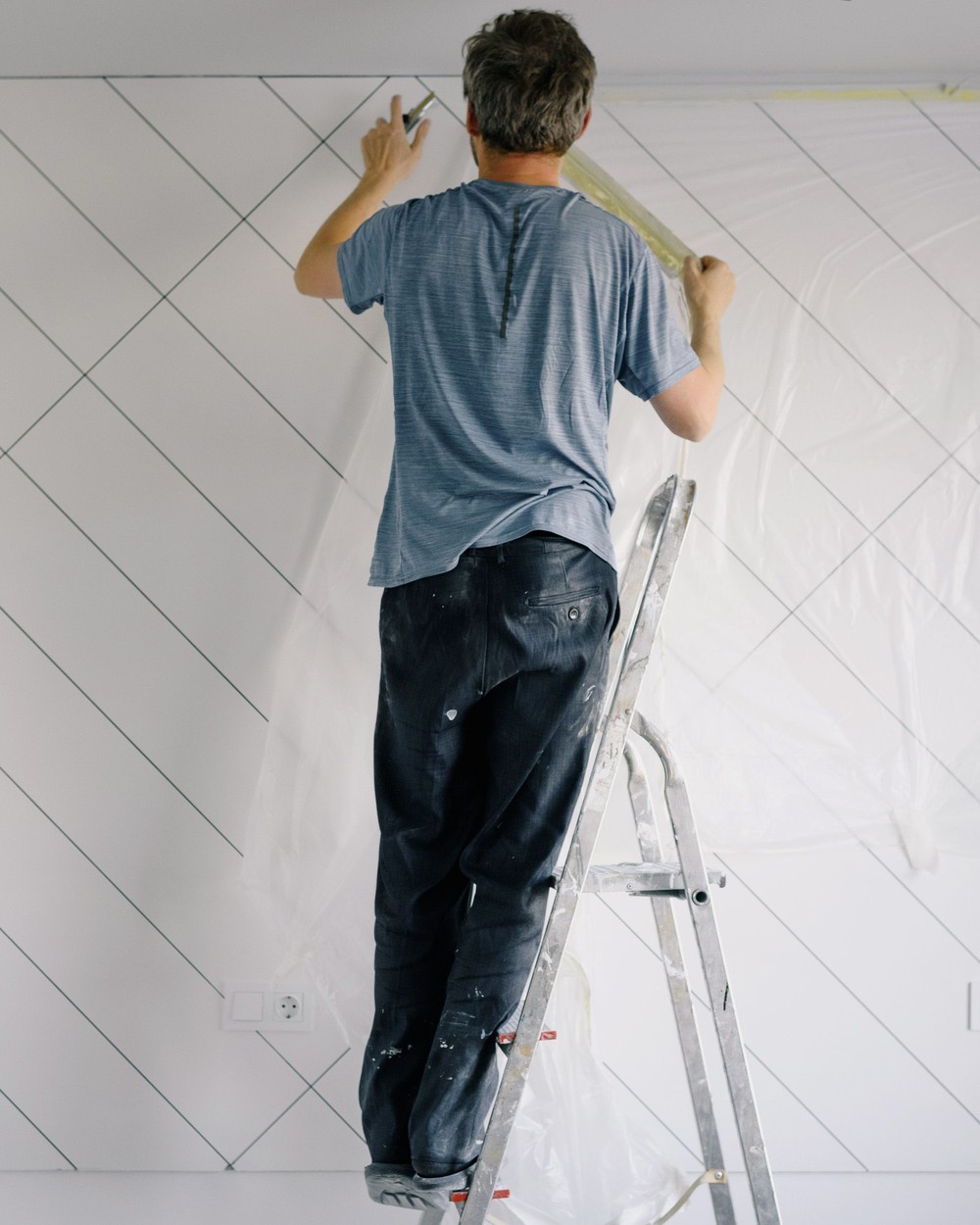 Taping a wall edge before painting, illustrative stock photo